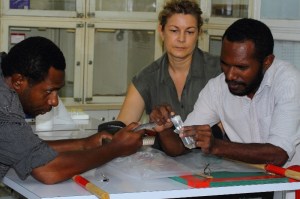 Diana Barr keeping a keen eye on her students as they perform venom extraction from a Papuan taipan under her instruction at the Charles Campbell Toxinology Centre in Papua New Guinea. (Left: Owen Paiva, right Benjamin Wawagu Bande). The venom is sent to the Instituto Clodomiro Picado in Costa Rica where it is used to produce lifesaving antivenom. This highly venomous snake has a nervous temperament which coupled with its speed and agility make it an extremely dangerous snake to work with. It is responsible for around one thousand deaths per year in Papua New Guinea.