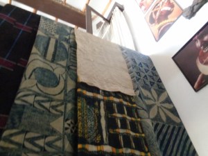 A collection of Yoruba hand woven and hand printed textiles at the African Heritage House. These textiles will be exhibited at the French Cultural Centre from 9-29 October. At the left is a piece of “Aseoke”, woven by men on narrow hand looms. The other cloths are examples of “Adire” with designs painted with cassava starch using a palm frond or feather, The cloth is then dipped several times in blue=black indigo dye,. Then the starch is chipped off and the cloth is dipped once more to get the light blue colour. copyright Rupi Mangat