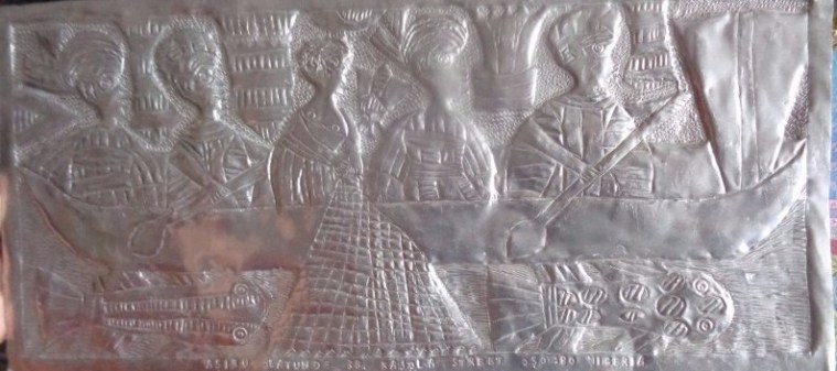 This is one of the metal panels based on Yoruba legend and mythology created by the late Asiru Olatunde and his son Folorunsho. This panel depicts women feeding the fish in the sacred river Osun, where women from all over the world come seeking fertility.