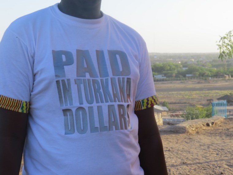 Turkana man on Loima Hill in Lodwar wearing T-shirt Paid in Turkana dollars Copyright Rupi Mangat